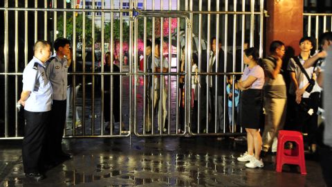 Locals and guards stand at the gate of the Dongfang Primary School after Monday's deadly attack.