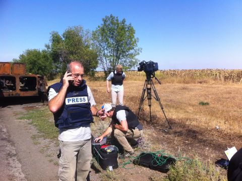From left: CNN's Tim Lister, Jeff Kehl and Diana Magnay set up for a shot beside a burnt-out vehicle in eastern Ukraine.