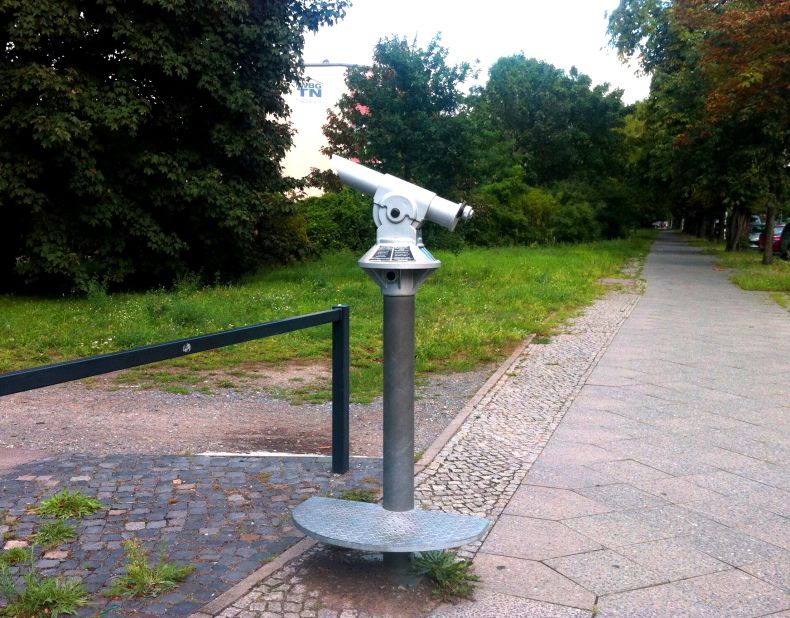"Ubergang -- Nahe und Distanz" (Crossing -- Proximity and Distance) by Heike Ponwitz stands at the former Sonnenallee border crossing. Inconspicuous gray telescopes symbolize mass surveillance during the era of the Berlin Wall.