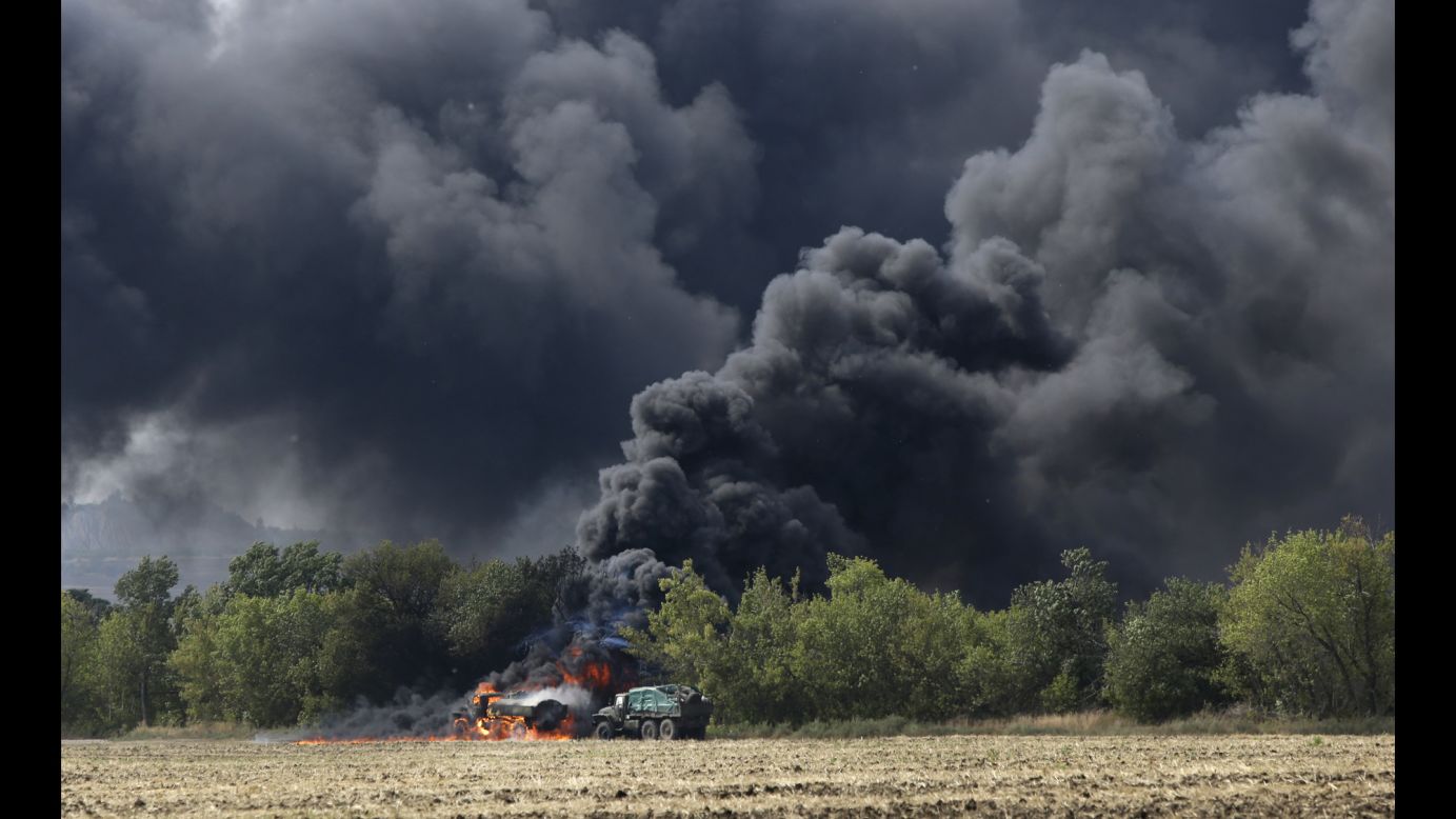 Unmarked military vehicles burn on a country road in Berezove, Ukraine, on September 4 after a clash between Ukrainian troops and pro-Russian rebels. For months, Ukrainian government forces have been fighting the rebels near Ukraine's eastern border with Russia. 