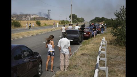 People wait by their cars near Berezove on September 4 as rockets hit the road ahead.