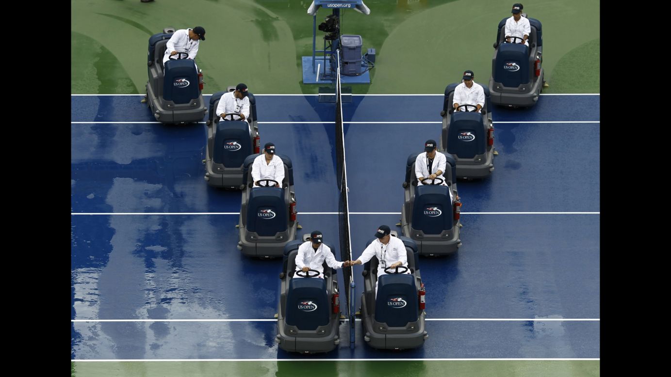 Workers at the U.S. Open tennis tournament dry a rain-soaked court Sunday, August 31, in New York.