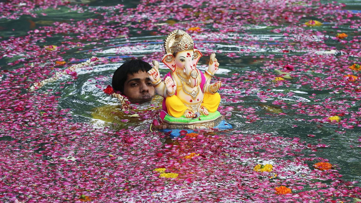 A man immerses an idol of the Hindu elephant god Ganesh in an artificial pond Saturday, August 30, during the 10-day Ganesh Chathurthi festival in Mumbai, India. 