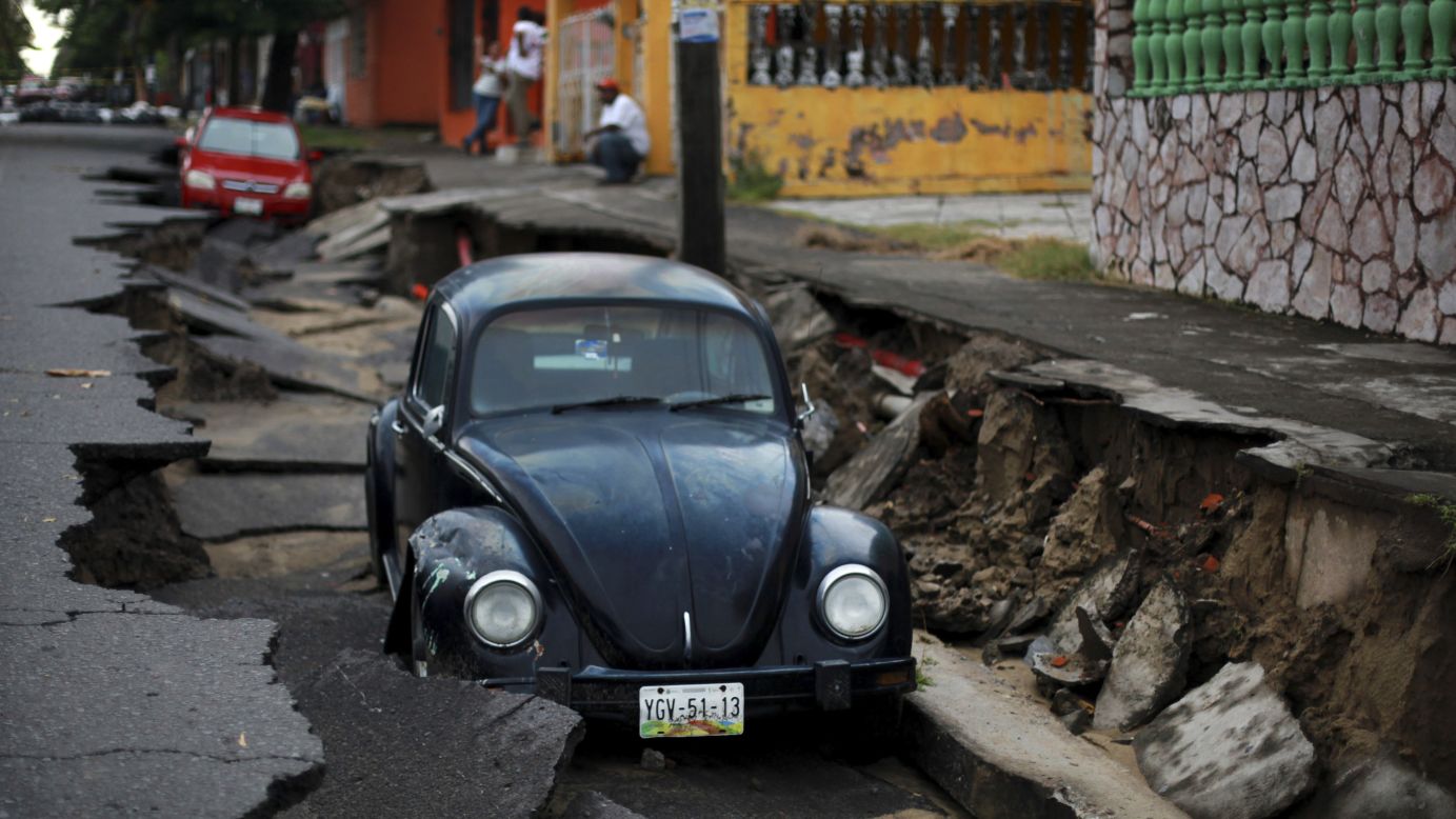 Cars sit on a street that collapsed after heavy rain in Veracruz, Mexico, on Tuesday, September 2.