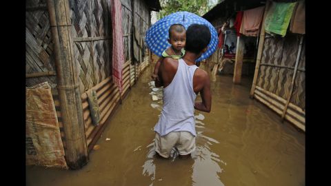 A man carries his son through floodwaters in Gauhati on September 5.
