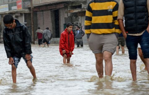 People wade through floodwaters September 5 on the outskirts of Srinagar.