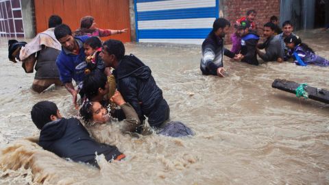 People struggle to pass through floodwaters Thursday, September 4, in Srinagar.