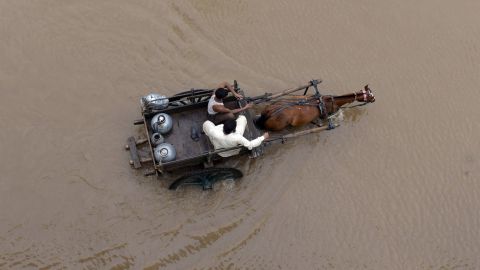 People ride on a horse-drawn cart through floodwaters in Lahore, Pakistan, on September 4.