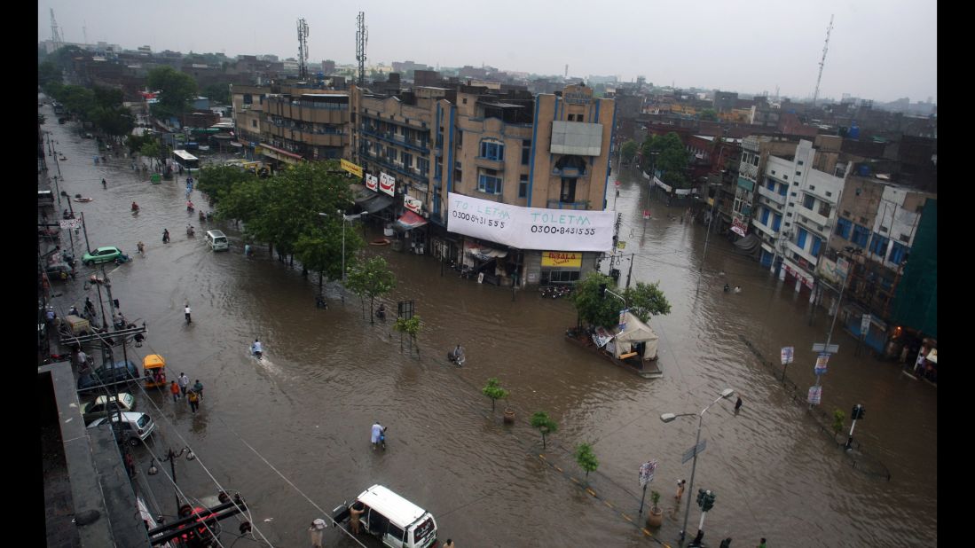 Motorcycles and vehicles move through flooded streets in Lahore on September 4.