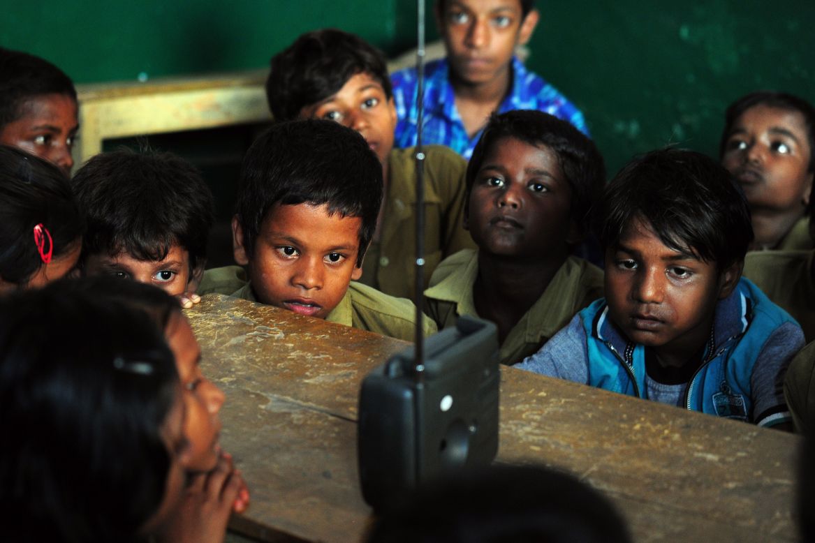 SEPTEMBER 5 - ALLAHABAD, INDIA: Schoolchildren crowd around a radio as they listen to a broadcast by Indian Prime Minister Narendra Modi delivering his Teachers' Day speech at a primary municipal school at Bakshi Kala Daraganj. Modi addressed hundreds of thousands of students during a live telecast to classrooms across India.