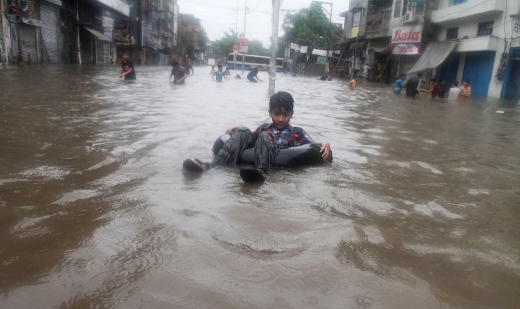 Children play in a road flooded by heavy rains in Lahore, Pakistan, on Friday, September 5. 