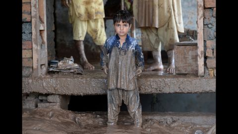 A child waits for his family to clean their home after flooding in Rawalpindi, Pakistan, on September 6.