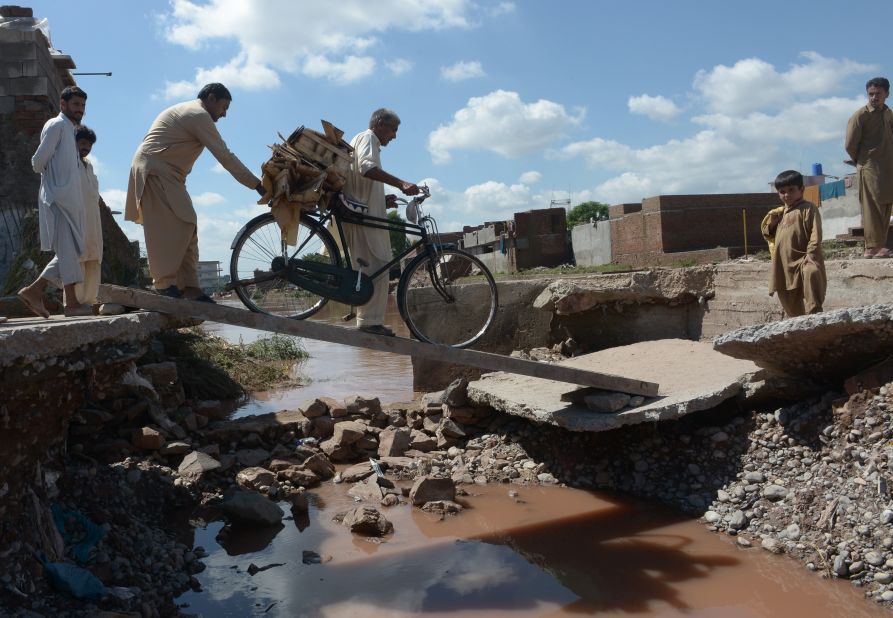 Residents cross a destroyed bridge after flooding in Islamabad, Pakistan, on September 6.
