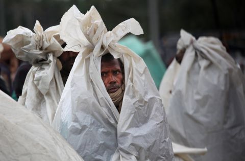Migrant workers in Srinagar huddle in plastic sheets as they camp on a highway after the area they were living in was inundated by floodwaters on September 6.