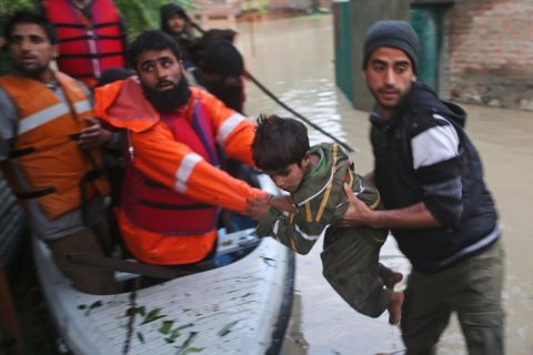 Volunteers help a child from a flooded area in Srinagar on Saturday, September 6. 