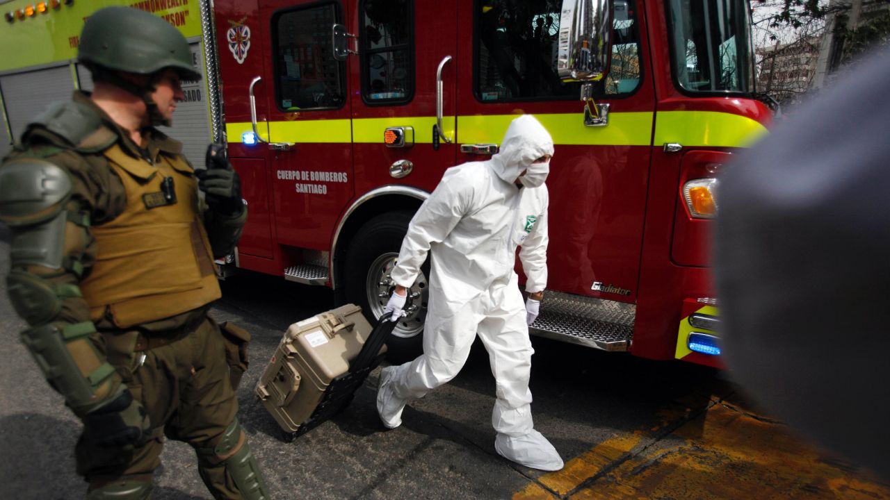 A police forensics expert arrives at the blast site at a subway station in Santiago, Chile, on Monday.
