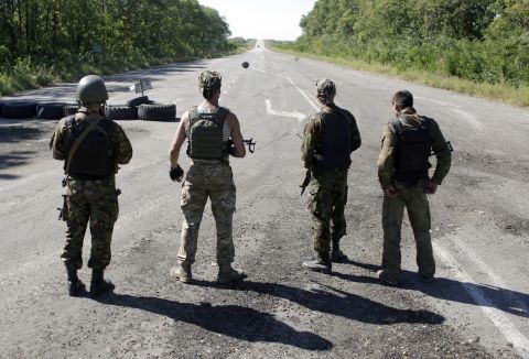 Ukrainian troops stand on a deserted road as they patrol the border area of the Donetsk and Luhansk regions Friday, September 5, near Debaltseve.