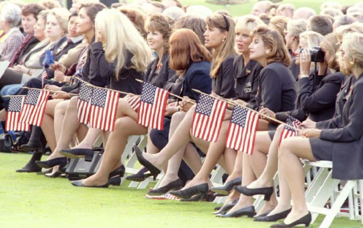 Las esposas y novias del equipo de Estados Unidos de la Ryder Cup sostienen banderas de su país durante la ceremonia de apertura de la Ryder Cup de 1995, en el Country Club de Oak Hill en Pittsford, Nueva York. 