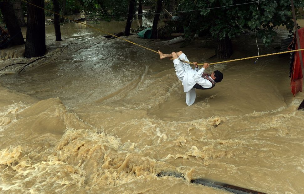 A man crosses over floodwaters with the use of a rope Tuesday, September 9, in Srinagar. 
