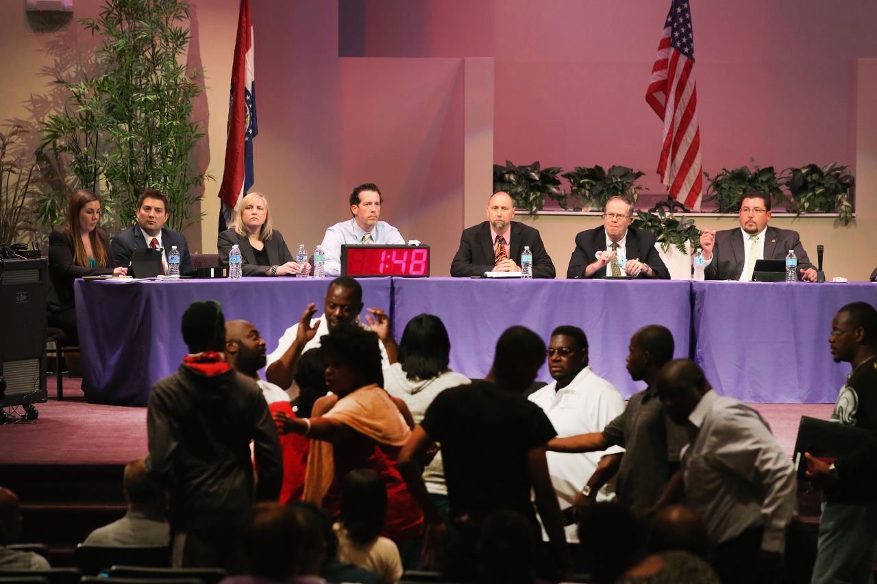 Mayor James Knowles, seated right, and council members wait for angry residents to calm down during a City Council meeting in Ferguson, Missouri, on Tuesday, September 9. The meeting was held at Greater Grace Church to accommodate the large crowd. Residents used the meeting to express their anger at how the police and council handled the August 9 shooting of teenager Michael Brown and the unrest that followed.