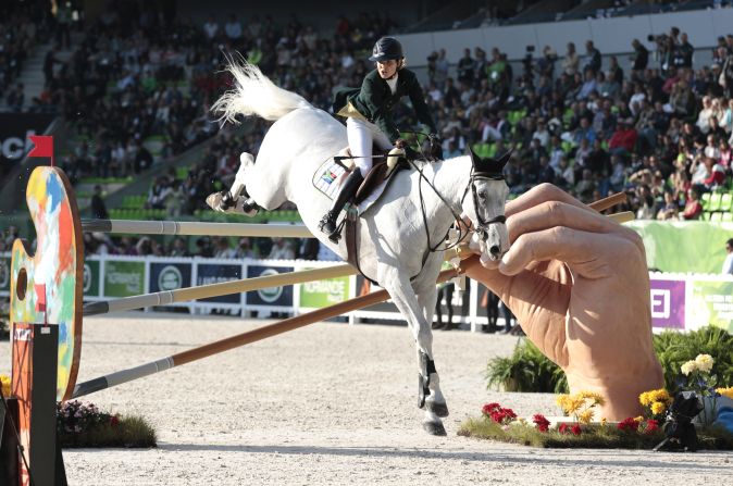 The jumping events were given a surreal Dali-esque twist with fantastical obstacles in the ring. Here, South African Cara Biana Frew takes a leap of faith over a giant painter's hand. 
