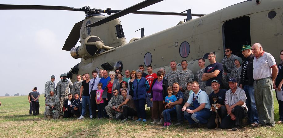 Residents of the village of Gruta, in northern Poland, pose for a photo with U.S. troops and their Chinook helicopter in the middle of a village field where six U.S. Army helicopters made an unplanned landing in poor weather on Tuesday, September 9.