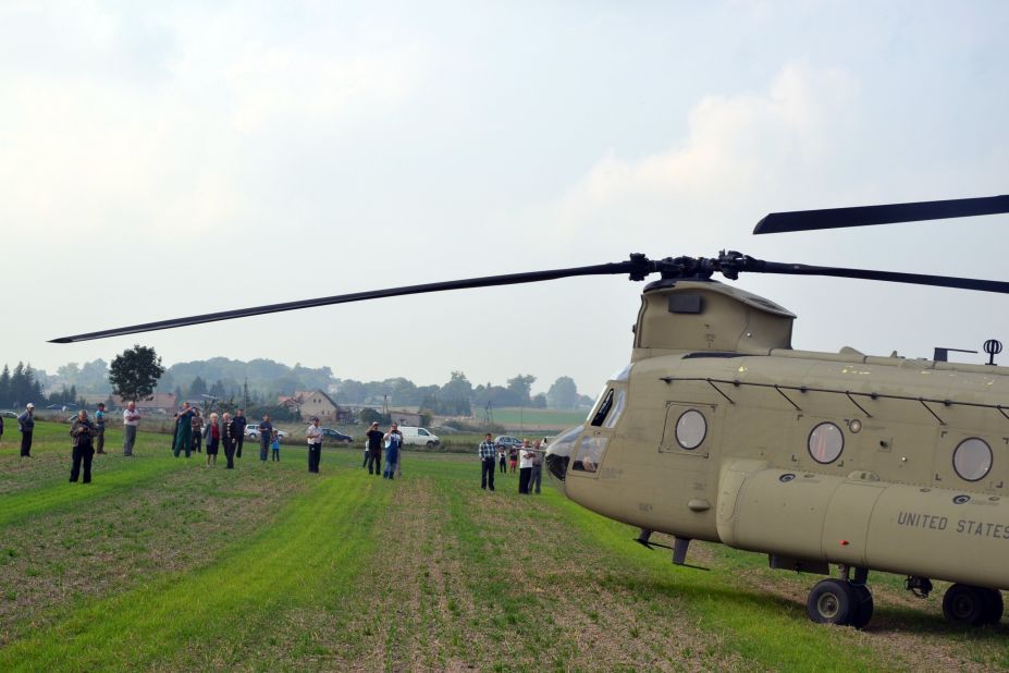Villagers look at the U.S. helicopters and their crews. Six other U.S. helicopters also made unplanned landings in the nearby village of Nowa Wies because of the weather. 