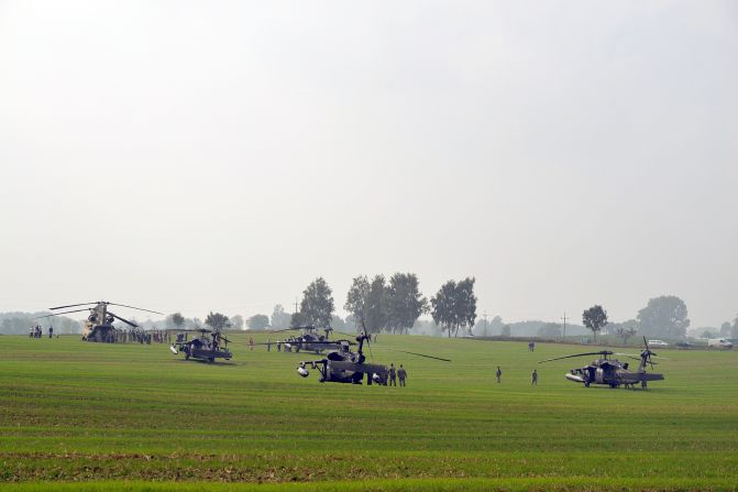 The U.S. helicopters and their crews are shown in the field. During the two-hour stay, they were a great attraction to the villagers.