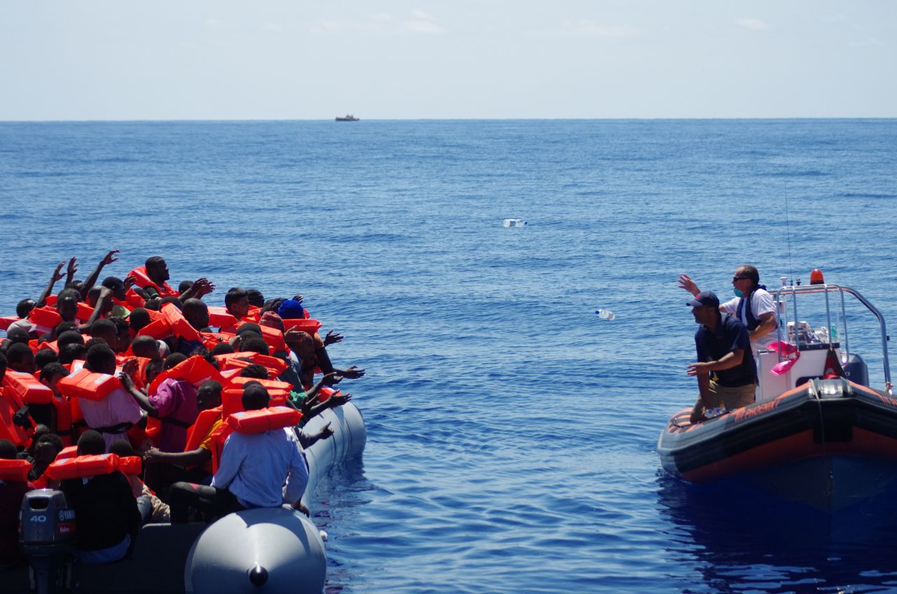 A lifeboat from rescue ship "Phoenix" approaches refugees, offering drinking water. "We never approach a boat with our boat because it's rather big, so we approach cautiously with a dingy. The first thing we do is start giving out life jackets," said MOAS director Martin Xuereb.