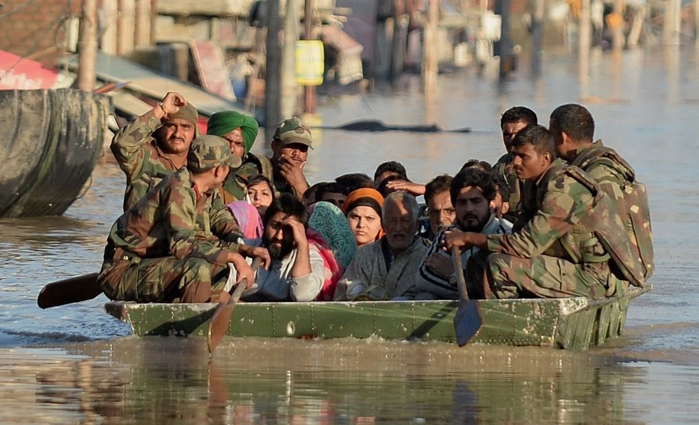 Flood-affected Kashmiri residents ride on an Indian Army raft in Srinagar on September 11.