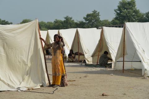 A woman displaced by recent flooding stands amid relief tents at the Athara Hazari area in Jhang, Pakistan, on September 11.