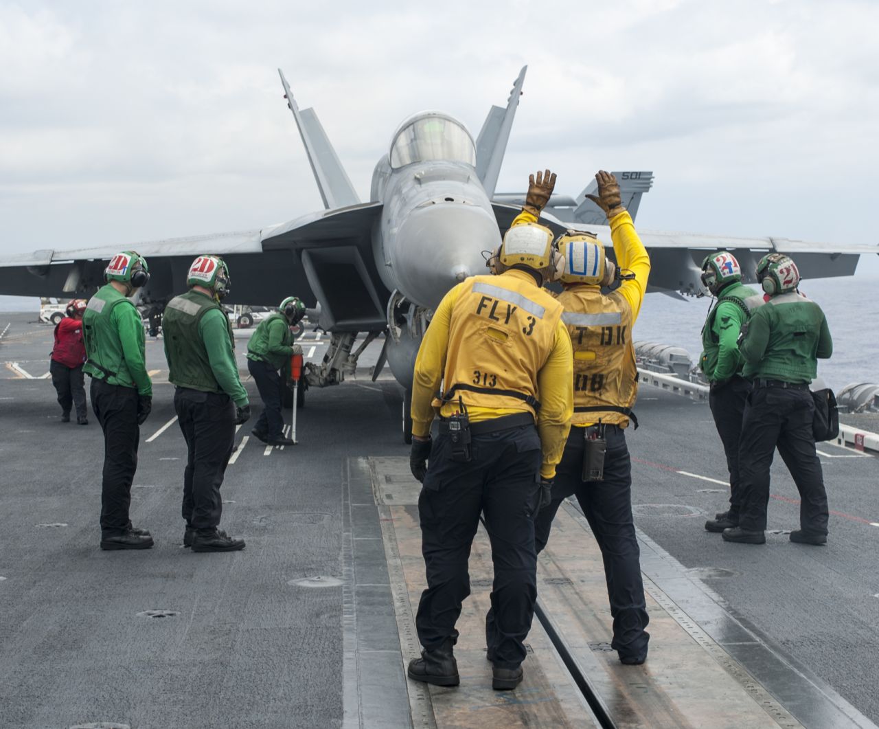 An F/A-18E Super Hornet from the Sunliners of Strike Fighter Squadron 81 taxis onto a catapult before launching from the flight deck of the aircraft carrier USS Carl Vinson.
