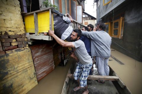 Volunteers help a flood victim from an alley in the city center of Srinagar on Friday, September 12. 