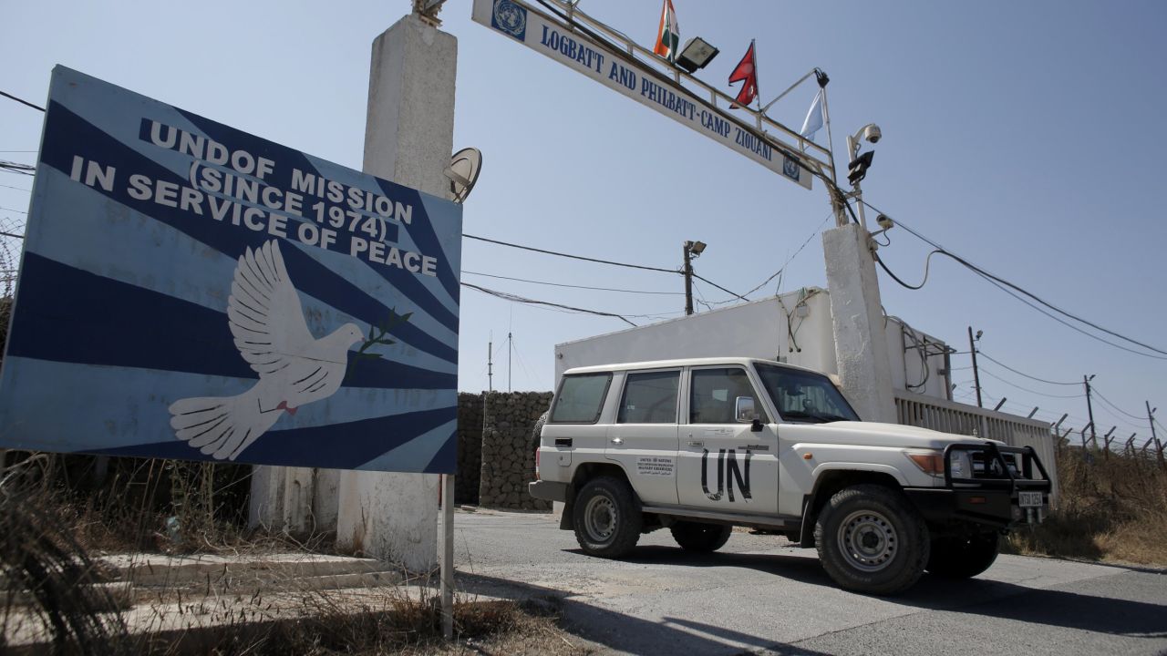 File: A UN peacekeeping car leaves the main UN headquarters next to the Quneitra crossing, the only border crossing between Israel and Syria, on August 30, 2014.
