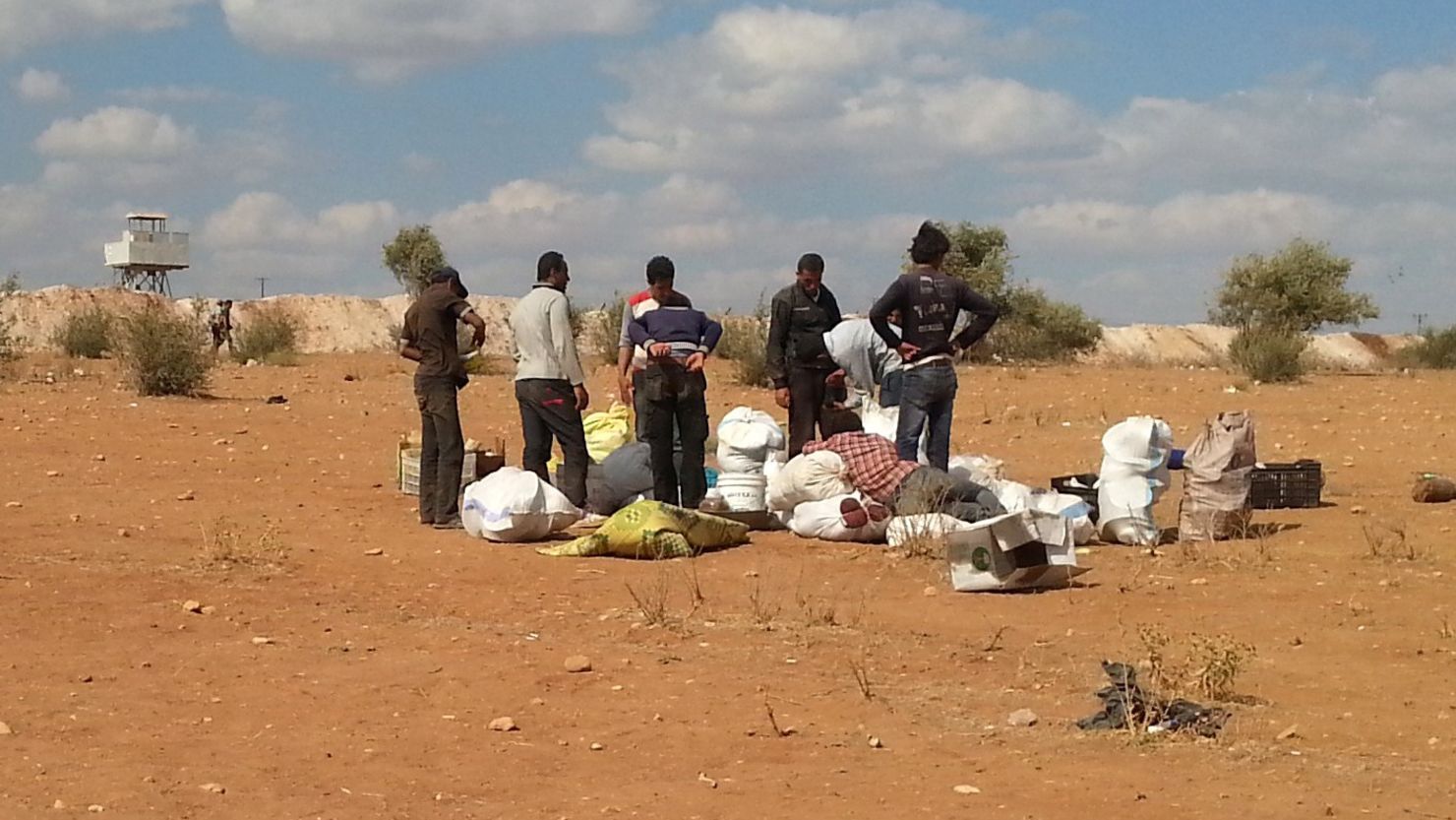 Syrians watch their belongings near the Syria-Turkey border as they try to cross illegally into Turkey on September 7.