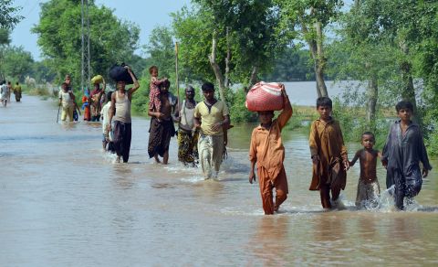 Residents wade through floodwaters Saturday, September 13, in Sher Shah, Pakistan. 