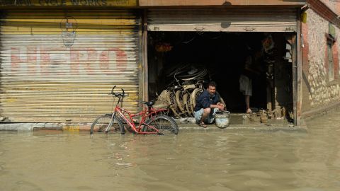 A Kashmiri shopkeeper looks on from his bicycle store as floodwaters recede in Srinagar on September 13.