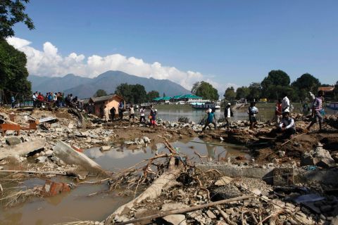People walk past a breached bank of the River Jhelum in Srinagar on September 13.