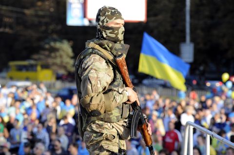 A Ukrainian soldier stands guard as residents rally in support of a united Ukraine in the southern Ukrainian city of Mariupol on September 13.