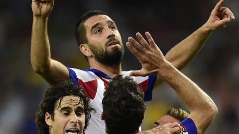 Arda Turan is hoisted skywards by his teammates after scoring Atletico Madrid's winner at the Bernabeu on Saturday. 