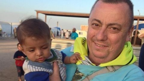 Alan Henning holds a child at a refugee camp on the Syria-Turkey border in this photo provided by his family. 