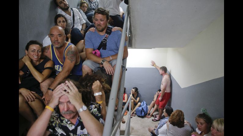 Tourists sit in a stairwell after a resort's shelter was damaged September 15 in Los Cabos.