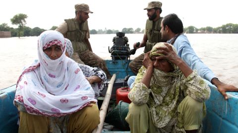 People ride in a military rescue boat after leaving their homes near Multan on September 13.
