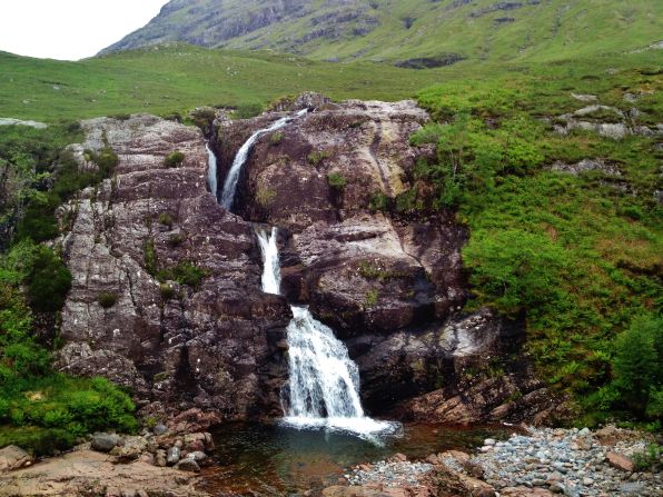 A waterfall splashes down the slopes of scenic <a href="http://ireport.cnn.com/docs/DOC-1159453">Glen Coe</a>, popular for both long walks and bus tours.
