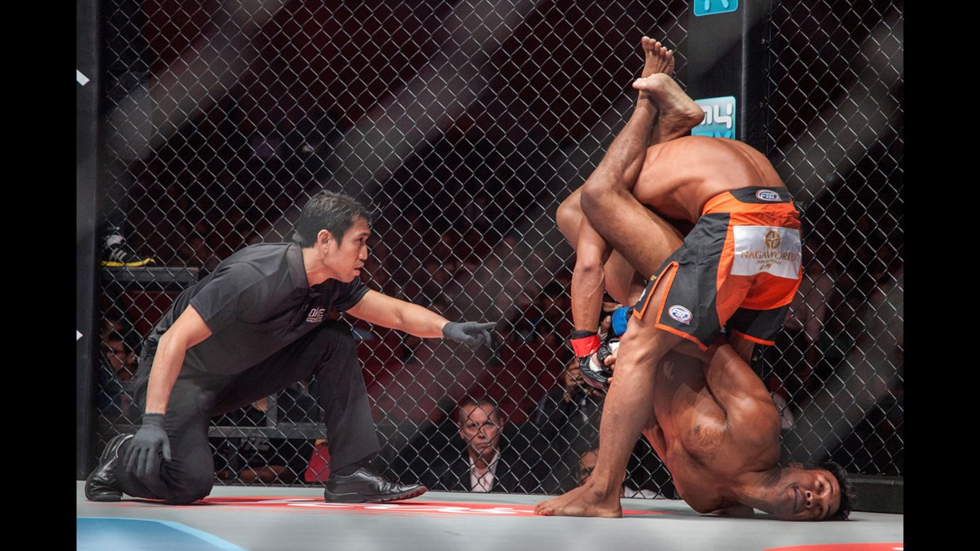 Sam Ang Dun, top, competes against Chin Heng during a mixed martial arts bout Friday, September 12, in Phnom Penh, Cambodia. Dun won by technical knockout in the first round.