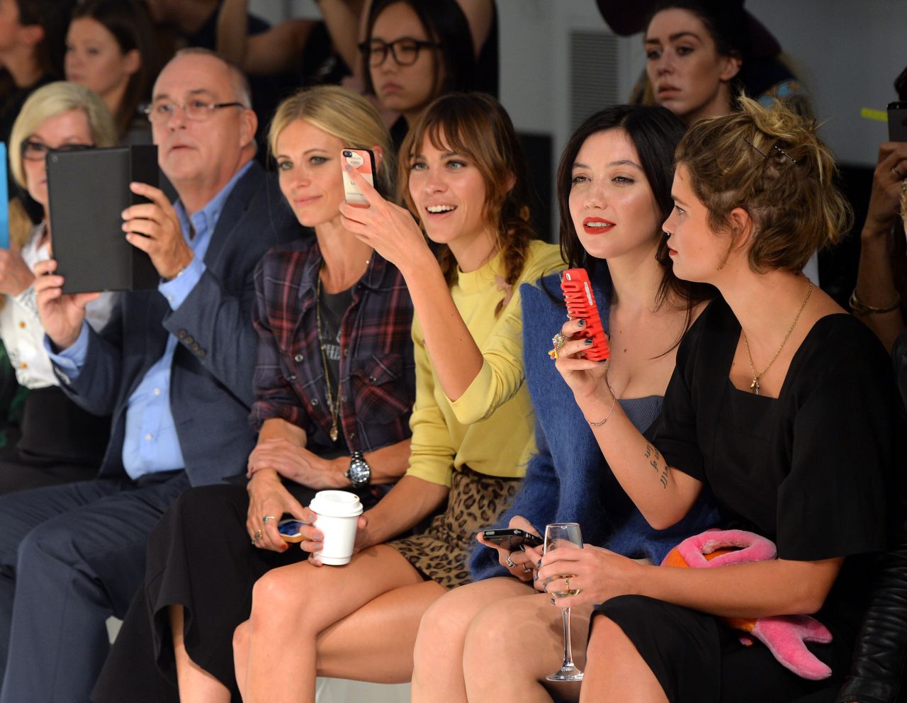 Celebrities including Alexa Chung and Pixie Geldof whip out their smartphones on the front row at London Fashion Week