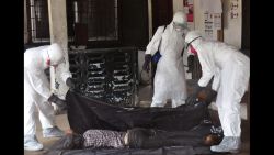Health workers in protective gear move the  body of a person that they suspect dyed form the Ebola virus in Monrovia, Liberia, Tuesday, Sept. 16, 2014. The number of Ebola cases in West Africa could start doubling every three weeks and it could end up costing nearly $1 billion to contain the crisis, the World Health Organization warned Tuesday.  (AP Photo/)