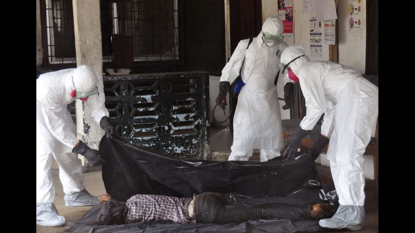 Health workers in protective gear move the body of a person that they suspect dyed form the Ebola virus in Monrovia, Liberia, Tuesday, Sept. 16, 2014. The number of Ebola cases in West Africa could start doubling every three weeks and it could end up costing nearly $1 billion to contain the crisis, the World Health Organization warned Tuesday. (AP Photo/)
