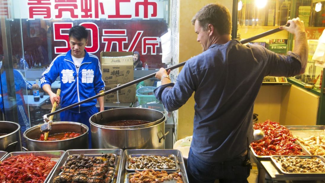 A cameraman gets an assist from a mounted GoPro for a close-up food shot in a Shanghai food stall.