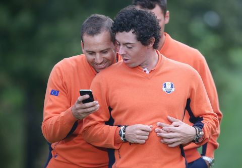 McIlroy y Sergio García revisan algo divertido en el teléfono celular del español durante un día de práctica antes de la Ryder Cup del 2012, ganado por Europa de manera dramática.